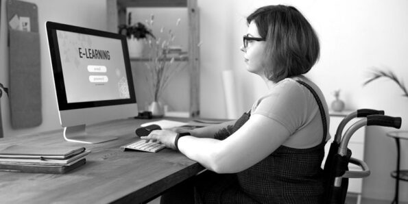 A woman in a wheelchair looks at a monitor which says eLearning.